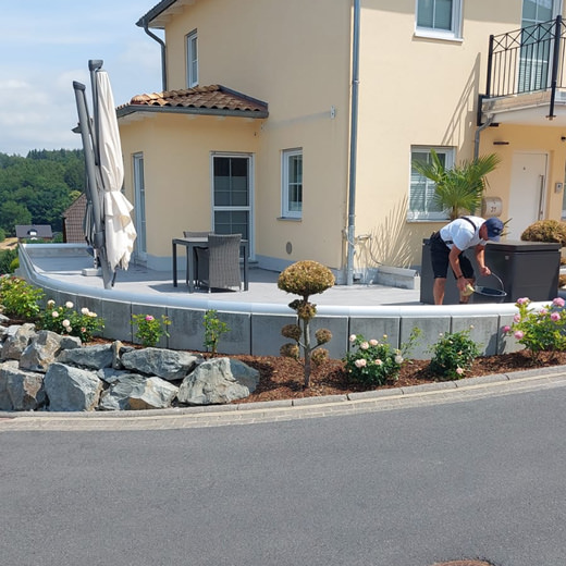 Ein Mitarbeiter putzt die Terrasse.